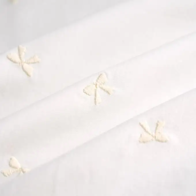 Tessuto popeline cotone ricamato fiocco ecru