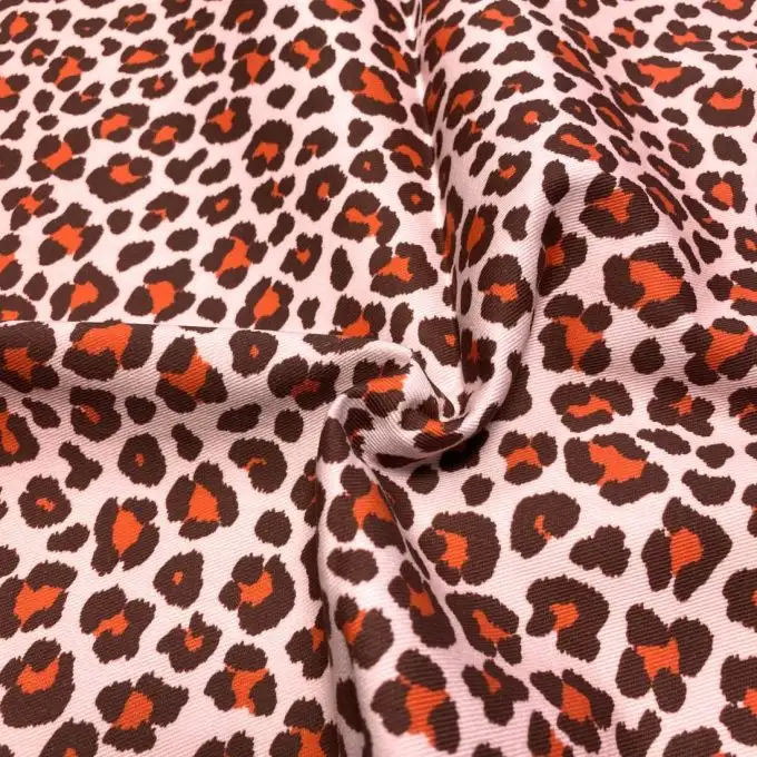 Tessuto twill cotone rosa chiaro grande leopardo rosso