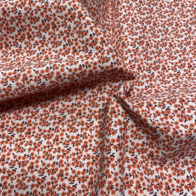 Tessuto voile di cotone morbido corallo mini margherite dense
